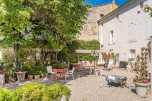 een binnenplaats met een tafel, stoelen en planten bij Hôtel La Suite in Villeneuve-lès-Avignon