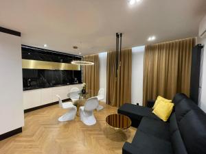 a living room with a black couch and a table at Apartamenty Manhattan in Legnica