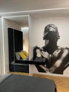 a mirror in a bedroom with a bust of a man at Apartamenty Manhattan in Legnica
