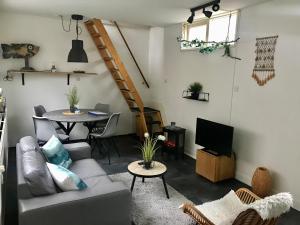 uma sala de estar com um sofá e uma mesa em Sommerhaus Glücklich am Meer 2 mit Wellnesszugang em Egmond aan Zee