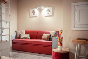 un soggiorno con divano rosso e tavolo di A'Coffa - Rooms&Breakfast a Taormina