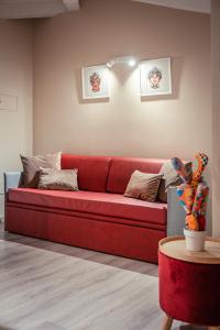 un sofá rojo sentado en una sala de estar en A'Coffa - Rooms&Breakfast, en Taormina