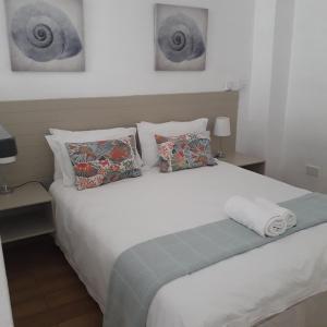 哈博羅內的住宿－Aflica Apartments，卧室配有带枕头的大型白色床