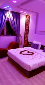 a bedroom with a large bed with purple lighting at Ahla Taif Apartments in Abha