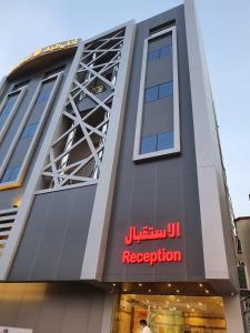 a building with a red sign on the side of it at Ahla Taif Apartments in Abha