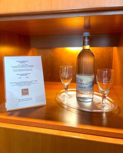 a bottle of wine sitting on a table with two glasses at SensCity Hotel Berlin Spandau in Berlin