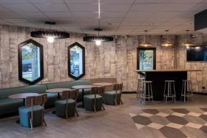 a bar in a restaurant with tables and stools at ibis Cergy Pontoise Le Port in Cergy