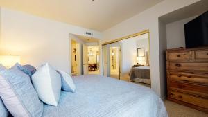 a bedroom with a bed and a dresser with a television at Silver Bear #21 condo in Mammoth Lakes +32 photos