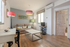un soggiorno con divano e tavolo di Hércules XCI Apartments a Siviglia