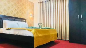 a bedroom with a bed with a yellow blanket on it at Eden Grand Bungalow Nuwaraeliya in Nuwara Eliya