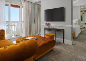 a living room with a couch and a television at Palace Elisabeth, Hvar Heritage Hotel in Hvar