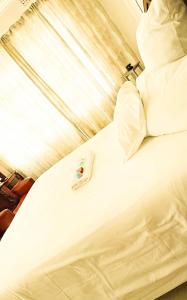 a bed with white sheets and pillows on it at Motjatji B&B in Burgersfort