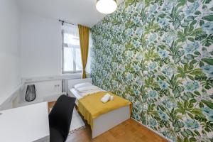 a bedroom with a small bed with a floral wallpaper at ROYAL ROOMS*** in Ljubljana