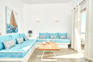 a living room with a blue couch and a wooden table at Agali Houses in Firostefani