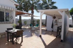 a pergola on a patio with a table and chairs at Villa LILAS in Els Poblets in Els Poblets