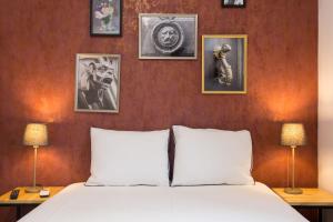 Schlafzimmer mit einem Bett und Bildern an der Wand in der Unterkunft City Escape - Lisbon Center! in Lissabon