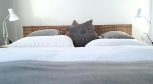 a bedroom with two beds with white sheets and pillows at Sommerloft Norderney in Norderney