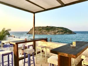 un tavolo e sedie su un patio con vista sull'oceano di Remezzo a Mochlos