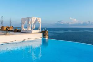 メガス・イアロス・ニテスにあるBluEros Luxury Villa - Syros Private Pool Gemの白い天蓋付きの海のスイミングプール