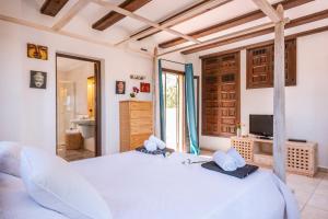 a bedroom with a large white bed and a television at Villa Luna in Jávea