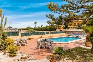 een patio met tafels en stoelen naast een zwembad bij Villa Luna in Jávea