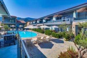 a view of the pool at a hotel with chairs and umbrellas at Theros Villas & Suites in Chrysi Ammoudia