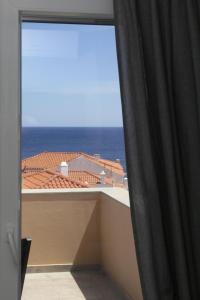 a view of the ocean from a room with a window at Camara Homes in Andros