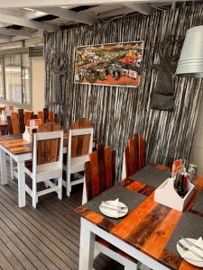 a dining room with wooden tables and chairs at Big Five Guest House in Mthatha