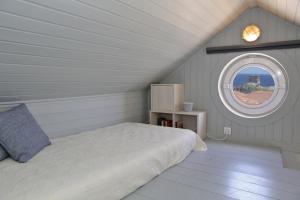 a bedroom with a bed and a round window at Camara Homes in Andros