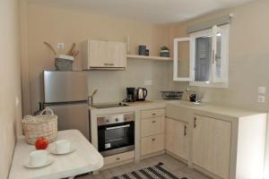 a kitchen with white cabinets and a stainless steel refrigerator at Camara Homes in Andros
