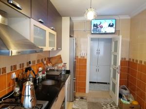 eine Küche mit einem Waschbecken und einem TV an der Wand in der Unterkunft Rahat ve sakin ev in Istanbul