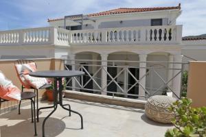 a balcony with a table and chairs in front of a house at Camara Homes in Andros