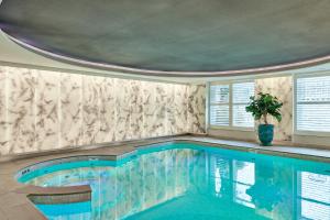 
a swimming pool with a large tub and a large window at De L’Europe Amsterdam – The Leading Hotels of the World in Amsterdam
