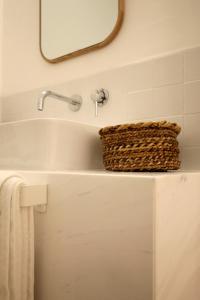 a bathroom sink with a basket on top of it at The King George Village Boutique Living in Għargħur +47 photos