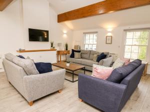 a living room with two couches and a table at Bridgend Cottages in Llandrindod Wells