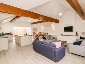 a living room with two couches and a kitchen at Bridgend Cottages in Llandrindod Wells