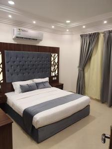 a bedroom with a large bed with a large headboard at Ahla Taif Apartments in Abha