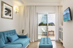 a living room with a blue couch and a window at Grand Hotel Cannigione in Cannigione