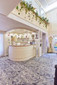 a lobby with a counter with flowers on the ceiling at HOTEL Villa Lilla in Desenzano del Garda