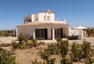 珀徹斯的住宿－Relaxing Casa da Vinha carvoeiro, Algarve，前面有树木的大白色房子