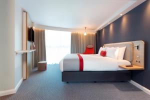 um quarto com uma cama grande e uma janela grande em Holiday Inn Express Southampton - M27, J7, an IHG Hotel em Southampton