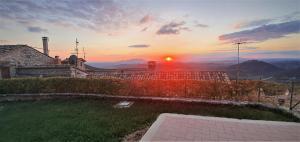 a sunset over a house with a view of the mountains at Piedirocca Apartments in Roccantica