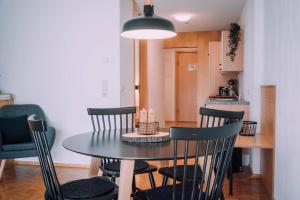 - une table à manger noire et des chaises dans la cuisine dans l'établissement Apartment Mohnenfluh, à Schröcken