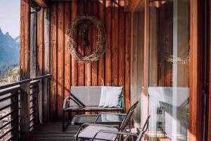 a porch with chairs and a wreath on a cabin at Apartment Mohnenfluh in Schröcken