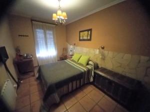 1 dormitorio con 1 cama con 2 almohadas de color verde lima en Posada de Campillo, en Campillo de Altobuey