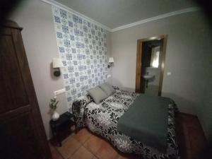 Un dormitorio con una cama y una mesa. en Posada de Campillo, en Campillo de Altobuey