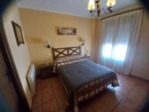 a bedroom with a bed in a room with a window at Posada de Campillo in Campillo de Altobuey