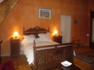 a bedroom with a large bed with two lamps at Au Mesnil Le Bas Bray in Bures-en-Bray
