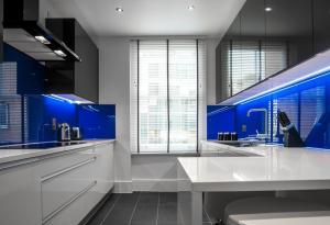 ロンドンにあるGarrick Mansions by Q Apartmentsの青い壁のキッチン(白いカウンタートップ付)