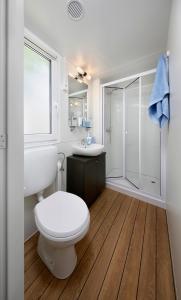 biała łazienka z toaletą i prysznicem w obiekcie Albatross Mobile Homes on Camping Laguna Village w mieście Porto Falconera
